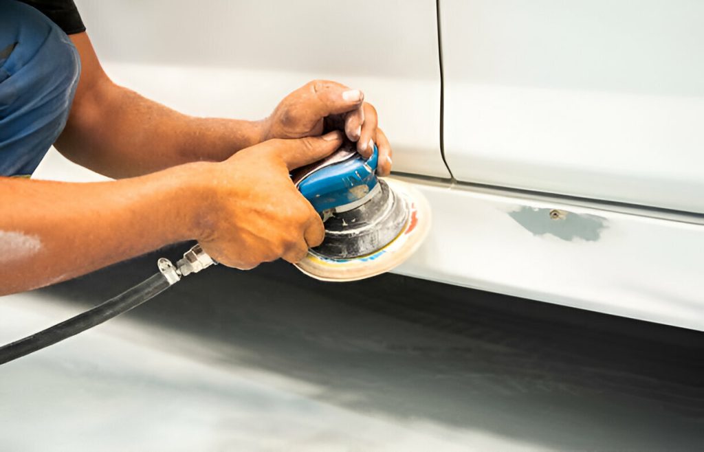 "A professional PDR technician carefully removing a dent from a vehicle."