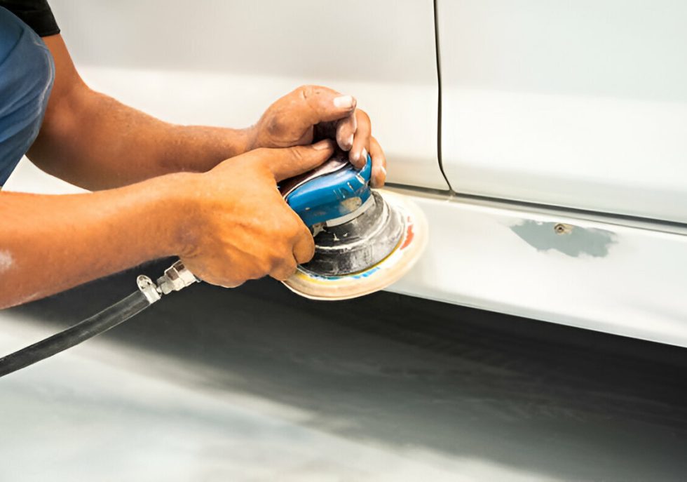 "A professional PDR technician carefully removing a dent from a vehicle."