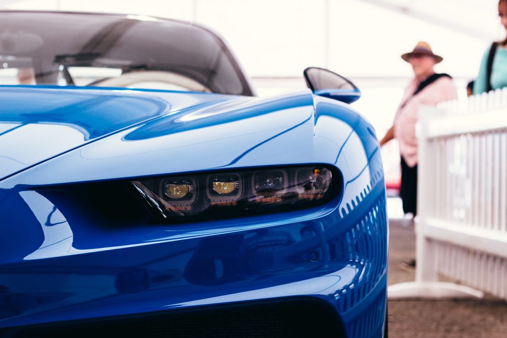 A technician performing paintless dent repair on a luxury vehicle."