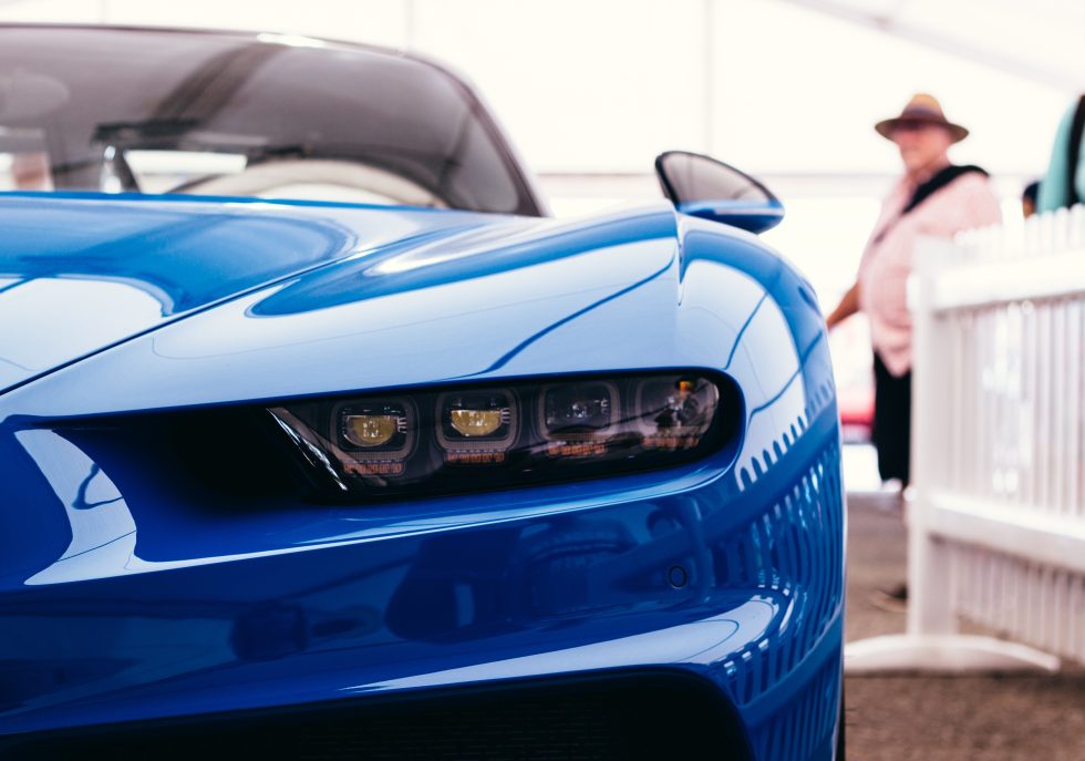 A technician performing paintless dent repair on a luxury vehicle."