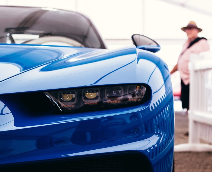 A technician performing paintless dent repair on a luxury vehicle."