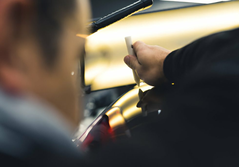 "A skilled technician using specialized tools to perform PDR on a vehicle.