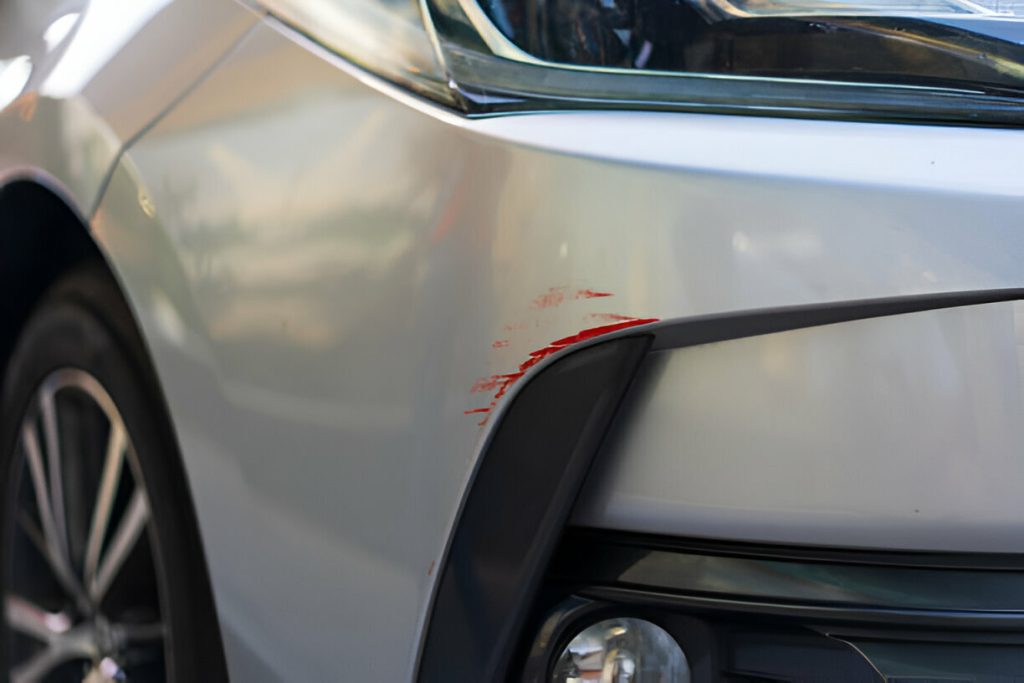 "Technician performing Paintless Dent Repair (PDR) on a car fender."
