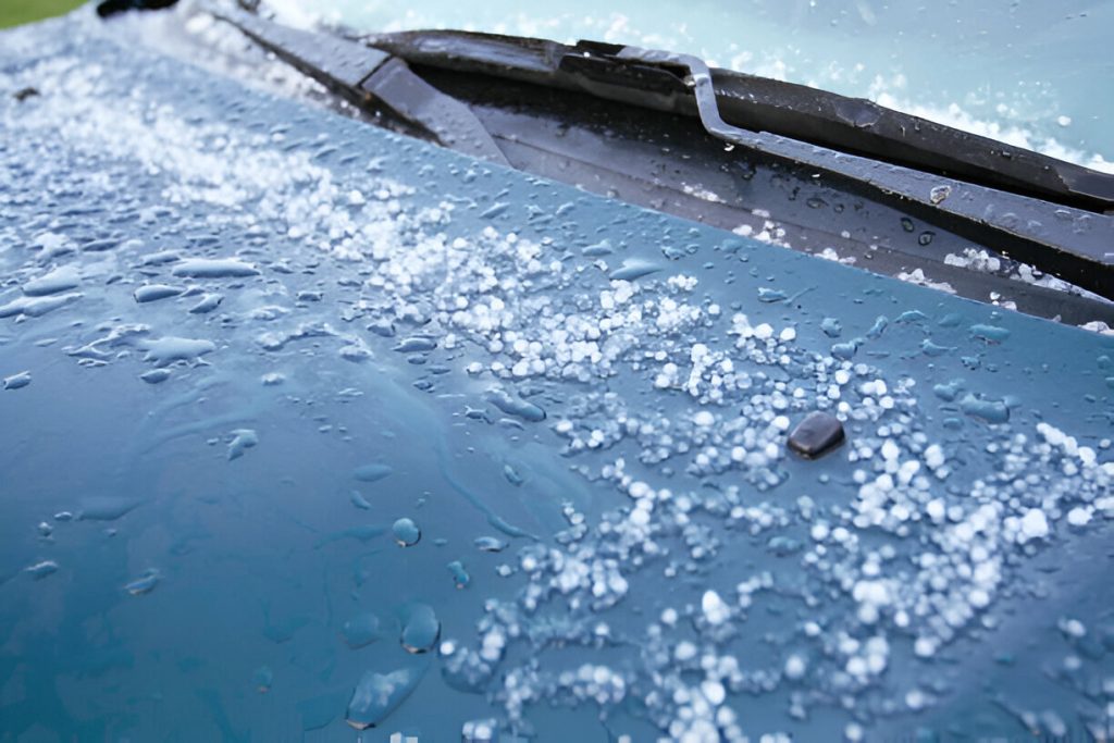 "Technician performing Paintless Dent Repair (PDR) on a hail-damaged car."