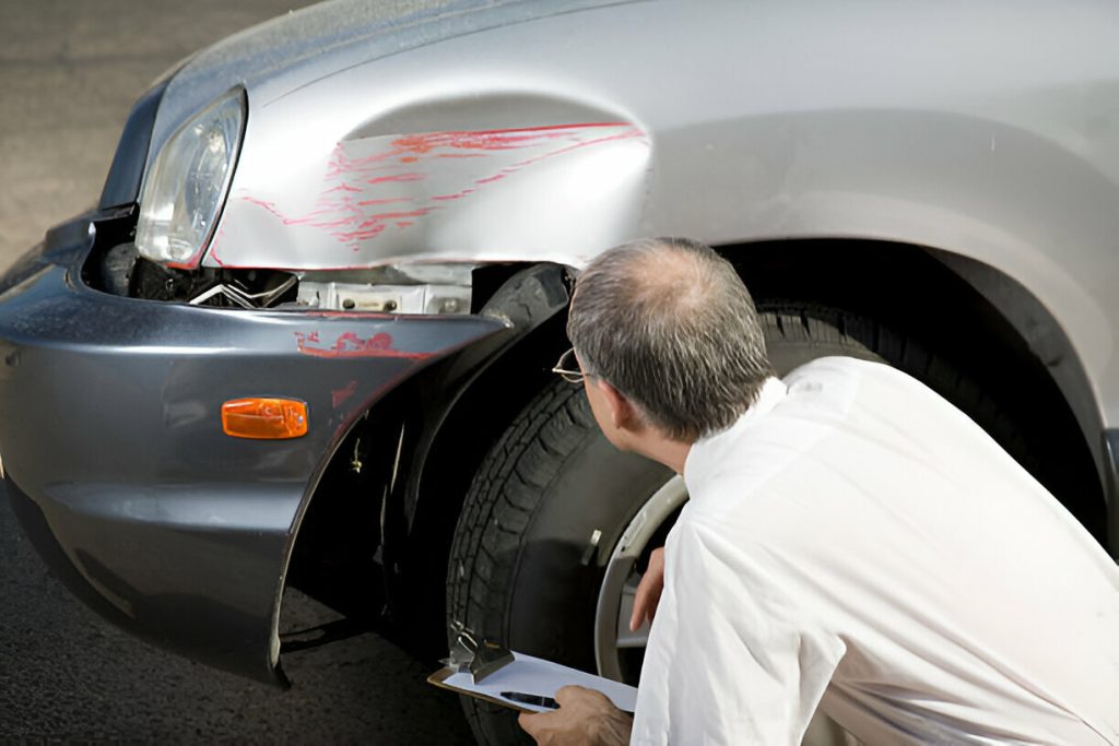 "Technician using PDR to remove a large dent from a car door."