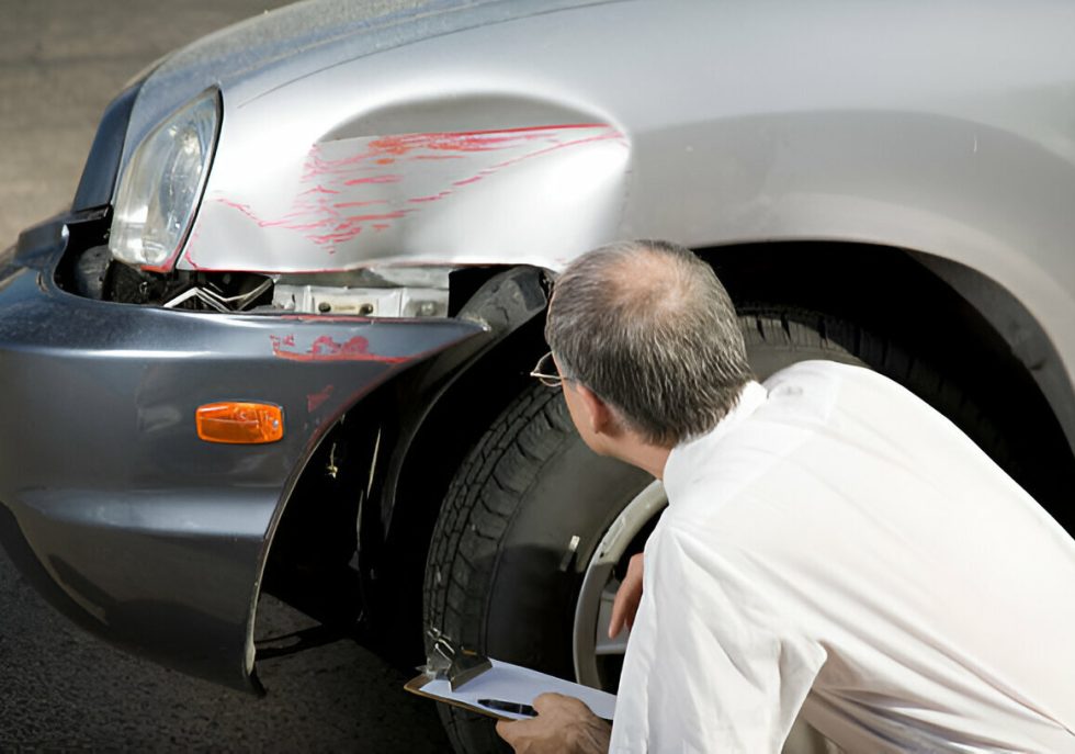 "Technician using PDR to remove a large dent from a car door."