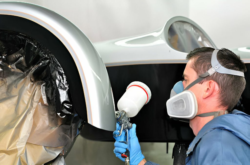"A mobile dent repair technician working on a car at a customer’s location."