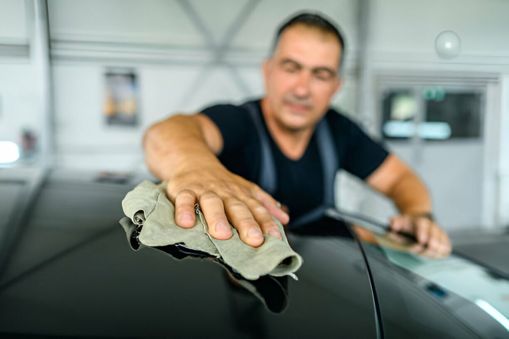 "Technician performing paintless dent repair on a car door."