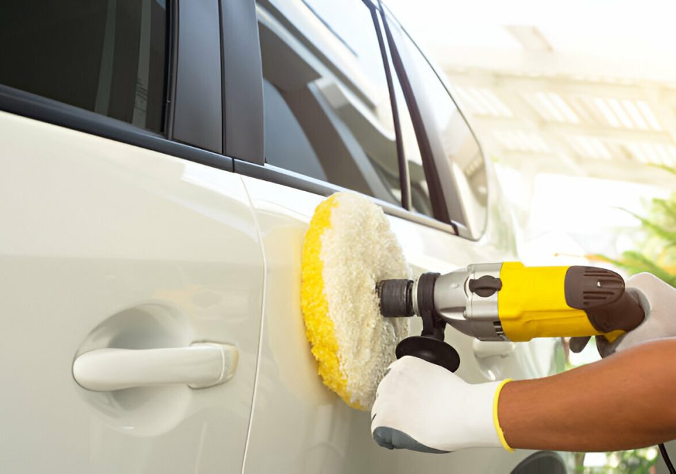 A technician performing paintless dent repair on a car’s door panel."