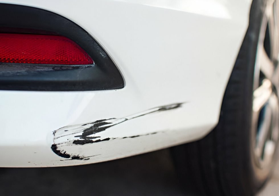 "Technician performing PDR on a dented plastic bumper."