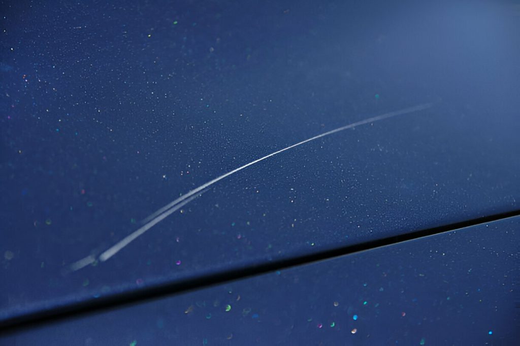 "Hand polishing a car’s hood to remove swirl marks and prevent scratches."