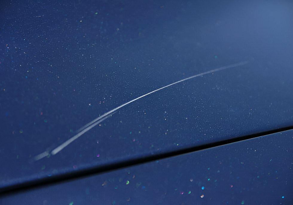 "Hand polishing a car’s hood to remove swirl marks and prevent scratches."