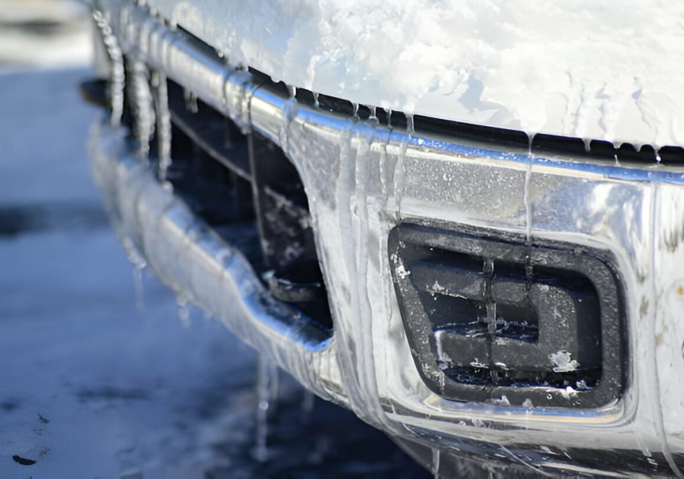 "Car covered in snow, parked safely to avoid winter-related dents."